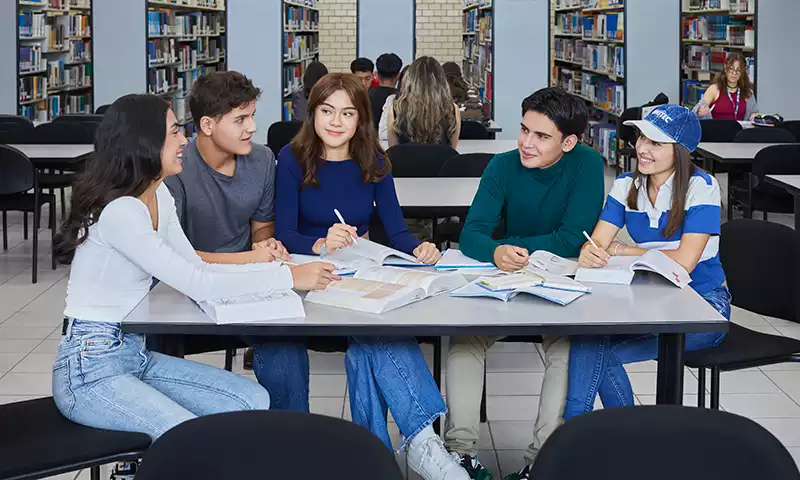 Cinco estudiantes de UNITEC en la bilbioteca de la escuela 